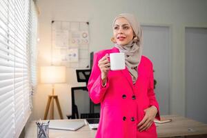 Business woman muslim. confident businesswoman muslim in hijab standing with folded arms near her workplace in office photo