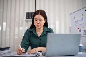 Businesswoman accountant using calculator and laptop for financial data saving in office room, Business financial, tax, accounting concept photo