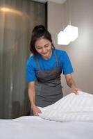 un mujer asiático personal limpieza servicio, herramienta y Cubeta para trabajar. un joven hembra limpiador con productos a limpiar un dormitorio foto
