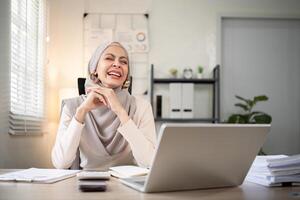 musulmán negocio mujer hijab trabajando acerca de financiero con negocio reporte y calculadora en ordenador portátil en hogar oficina foto