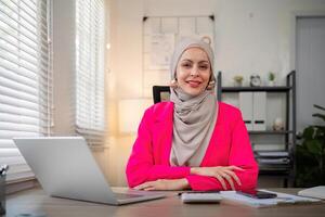 musulmán negocio mujer hijab trabajando acerca de financiero con negocio reporte y calculadora en ordenador portátil en hogar oficina foto