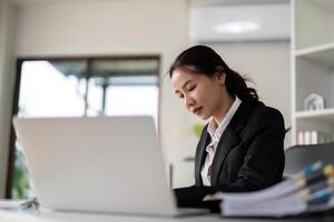 Asian woman accounting sit at their desks and calculate financial graph showing results about their investment, planning successful business growth process photo