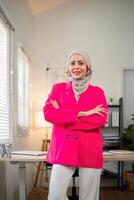 Business woman muslim. confident businesswoman muslim in hijab standing with folded arms near her workplace in office photo