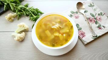 Homemade chicken vegetable soup on rustic wooden background video