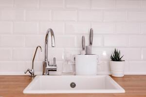 limpiar blanco lavabo en de madera mesa en blanco cocina foto