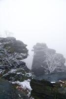 On the large Zschirnstein in fog. Rock covered with snow. Viewpoint Elbe Sandstone Mountains photo