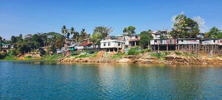 Rural house on silts hill tribe settlements along the coastline of Kaptai lake photo