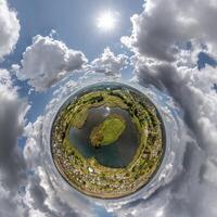 simple tiny planet without buildings in blue sky with beautiful clouds. Transformation of spherical panorama 360 degrees. Spherical abstract aerial view. Curvature of space. photo