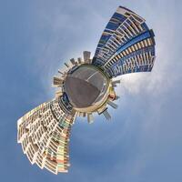 abstract swirling tiny planet spherical panorama of multi-storey buildings of skyscrapers of a residential complex in the form of a butterfly in blue sky photo