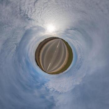 simple tiny planet without buildings in blue sky with beautiful clouds. Transformation of spherical panorama 360 degrees. Spherical abstract aerial view. Curvature of space. photo