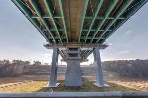 acero marco y hormigón construcción enorme coche puente a través de el amplio río. foto