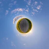 simple tiny planet without buildings in blue sky with beautiful clouds. Transformation of spherical panorama 360 degrees. Spherical abstract aerial view. Curvature of space. photo