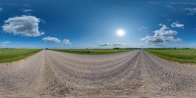 360 hdri panorama on gravel road with marks from car or tractor tires with clouds on blue sky in equirectangular spherical seamless projection, skydome replacement in drone panoramas photo