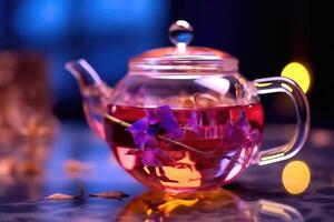 Aromatic Tea in Glass Teapot on Soft Purple Background photo