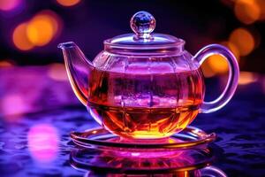 Transparent Glass Teapot with Tea on Blurred Purple Background photo