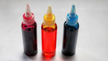 three different colored ink bottles are shown photo