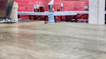 Empty wooden table and chairs in a coffee shop with brick wall background photo