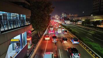 un ocupado calle a noche con carros y autobuses foto