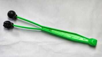 a pair of green plastic tongs with black handles photo