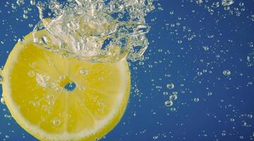 Underwater lemon slice in soda water or lemonade with bubbles. photo