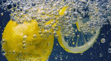 Underwater lemon slice in soda water or lemonade with bubbles. photo