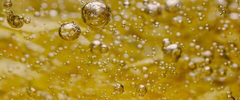 Golden Hyaluron Oil bubbles collagen serum or yellow oil bubbles drop texture background photo