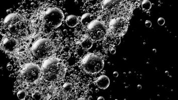 Soda water bubbles splashing underwater against black background. photo