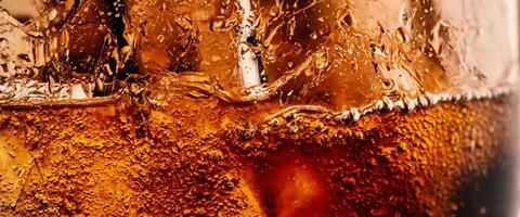 Splashing of Cola and Ice. Cola soda and ice splashing fizzing or floating up to top of surface. Close up of ice in cola water. Texture of carbonate drink with bubbles in glass. Cold drink background photo