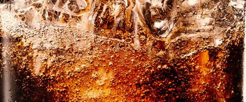 Splashing of Cola and Ice. Cola soda and ice splashing fizzing or floating up to top of surface. Close up of ice in cola water. Texture of carbonate drink with bubbles in glass. Cold drink background photo