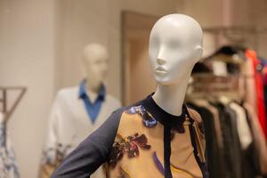 Female mannequin in floral clothing in a store window. photo