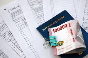 Indonesian tax forms 1770 Individual Income Tax Return and money with passport photo