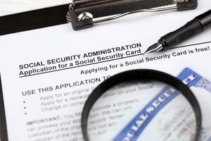 unido estados social seguridad número tarjetas mentiras en solicitud desde social seguridad administración en a4 tableta mentiras en oficina mesa con bolígrafo y aumentador vaso foto