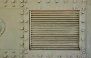 The texture of the wall of the tank, made of metal and reinforced with a multitude of bolts and rivets. Images of the covering of a combat vehicle from the Second World War photo