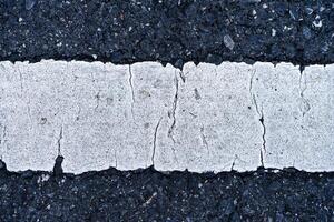 Old white traffic lines on the road. photo