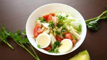 frisch Gemüse Salat, Kohl, Tomaten im ein Schüssel auf ein hölzern Tabelle video