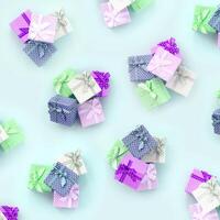 Piles of a small colored gift boxes with ribbons lies on a violet background. Minimalism flat lay top view pattern photo