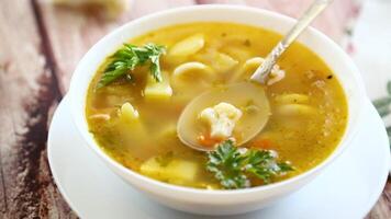 Homemade chicken vegetable soup on rustic wooden background video