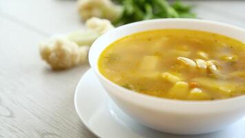 Homemade chicken vegetable soup on rustic wooden background video