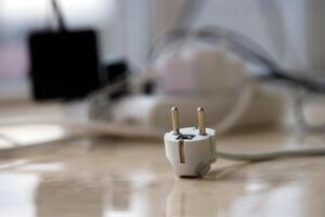 Overloaded power boards. Power strips with different electrical plugs on white floor photo