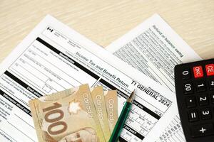 Canadian T1 General tax form Income tax and benefit return lies on table with canadian money bills photo