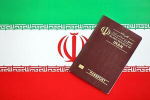 Red Islamic Republic of Iran passport on national flag background close up photo