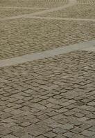 The texture of the paving slab paving stones of many small stones of a square shape under bright sunlight photo