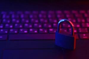 Computer security concept with a closed padlock on the keyboard. Padlock on top of a laptop keyboard. Selective focus photo