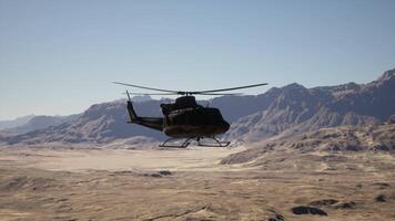 A helicopter flying over a desert landscape with mountains in the background video