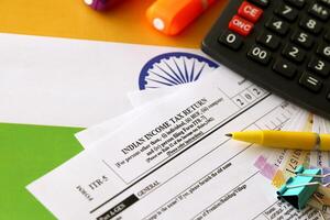 Indian income tax return blank form with pen and indian rupees bills photo