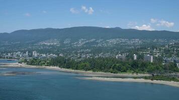 Lions Gate Bridge Traffic, Mountains, Park Summer Day Stanley Park shooting namaz that iron structure the sun is shining Clear sky ships airplanes Pacific Ocean view of Stanley Park video