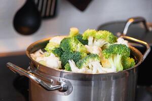 brócoli y coliflor son al vapor en un cacerola - sano dieta, bebé alimento, Cocinando en un buque de vapor foto