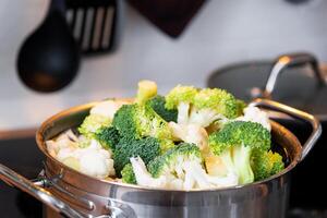 brócoli y coliflor son al vapor en un cacerola - sano dieta, bebé alimento, Cocinando en un buque de vapor foto