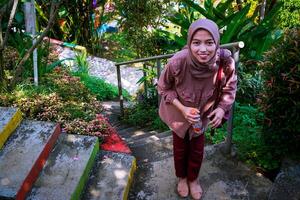 top view of a woman in a headscarf walking on the park steps facing the camera. photo