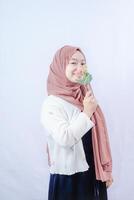 woman in hijab kissing plastic flowers on white background with empty space for photocopy. photo